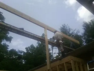 Carpenter setting a ridge beam over a new addition frame — Ice Dam Removal by Roofing Brothers in New Paltz