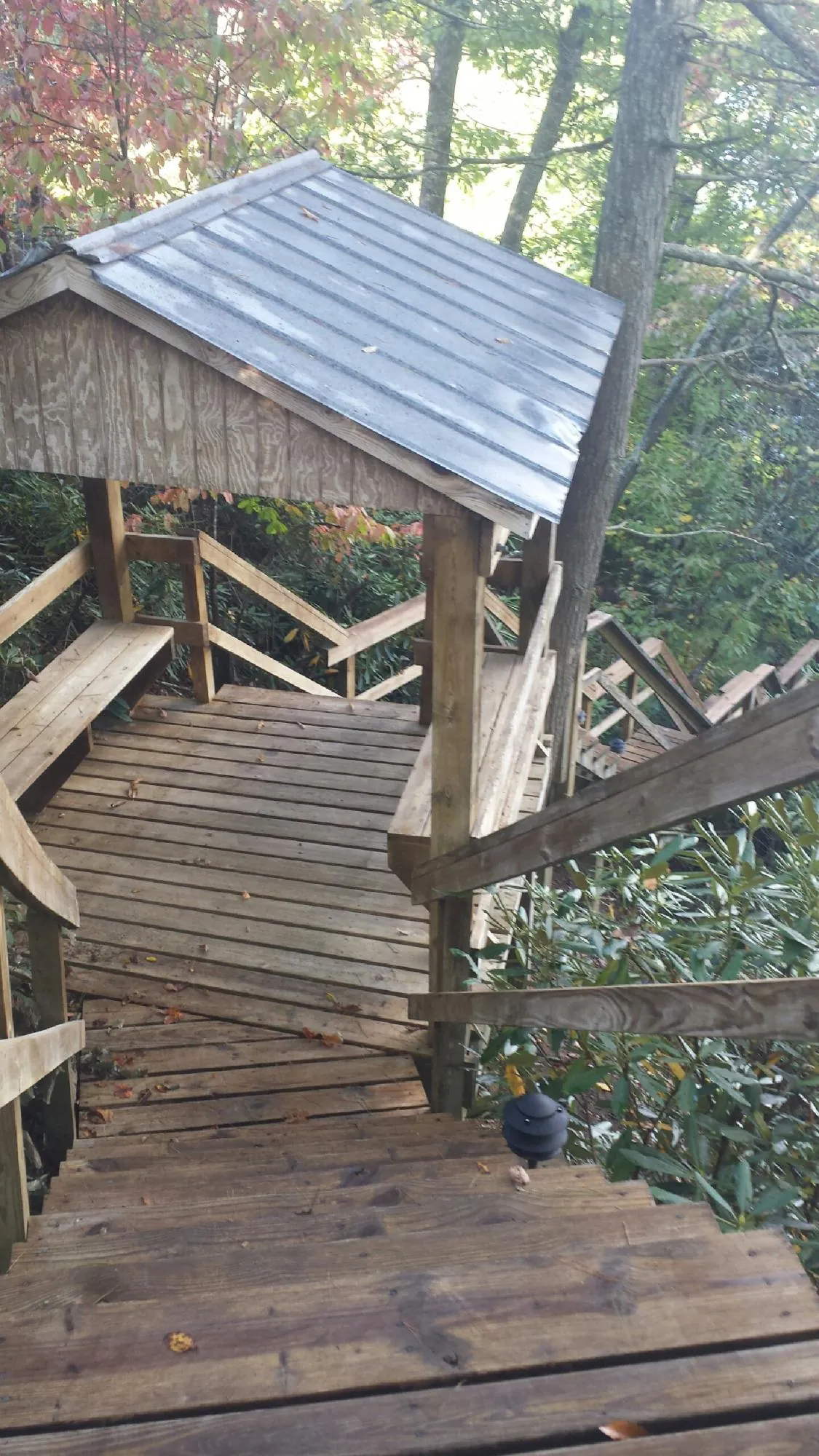 Metal roofed shelter over wooden steps on a wooded walkway — Skylight Repair & Installation work by our crew in New Paltz